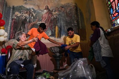 Los voluntarios clasifican la ropa donada para las víctimas de la tragedia en Tejerías, el 10 de octubre de 2022.