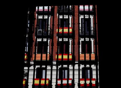 Banderas españolas y catalanas colgadas de balcones en un edificio de apartamentos en Madrid, España.