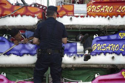 Un policía ayuda a un inmigrante a salir de su escondite, en el interior de una atracción de feria en Ceuta.