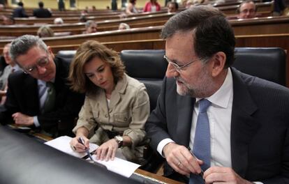 El ministro de Justicia, Alberto Ruiz-Gallardón, junto a la vicepresidenta del Gobierno, Soraya Sáenz de Santamaría y el presidente del Gobierno Mariano Rajoy durante el pleno del Congreso de los Diputados.