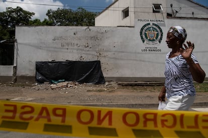 Una mujer pasa frente a la fachada de la Estación de Policía Los Mangos, afectada por una de las explosiones en el oriente de Cali.