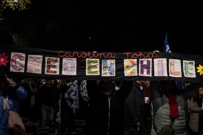Un grupo de mujeres sostiene una arpillera por Carolina Tohá.