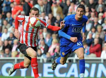 Philips Bardsley (izquierda) corre junto al delantero italiano del Manchester Federico Macheda.