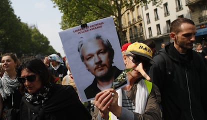 Uma mulher mostra uma foto do fundador do Wikileaks, Julian Assange, durante a manifestação em 1º de maio, em Paris.