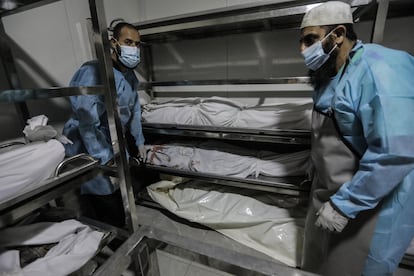 Dos hombres trasladan varios cadáveres en la morgue del hospital de Jan Yunis, este jueves. 
