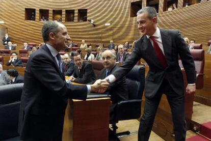 El presidente valenciano, Francisco Camps (a la izquierda), saluda al diputado Ricardo Costa durante el pleno de las Cortes.