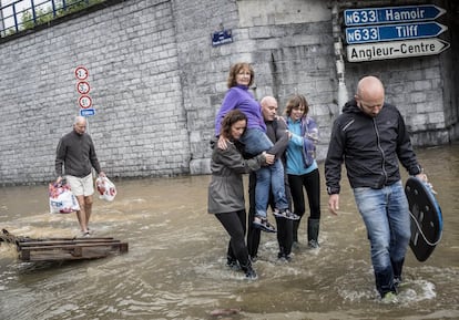 Una mujer es llevada en brazos a través de una calle inundada en Angleur, provincia de Lieja, Bélgica, el viernes 16 de julio de 2021. Las graves inundaciones en Alemania y Bélgica han convertido los arroyos y las calles en furiosos torrentes que han arrastrado coches y provocado el derrumbe de casas. 