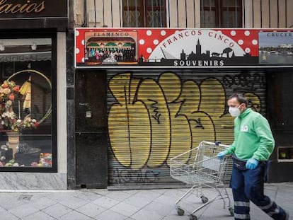 A man walks past closed stores during the coronavirus lockdown in Spain.