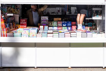 Dos personas ultiman los preparativos de su caseta, de cara a la inauguración de la Feria del Libro.