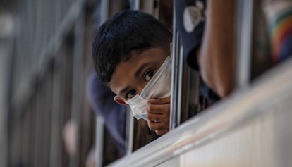 Un niño con mascarilla se asoma a la ventana de un autobús en Manila, capital filipina, el 13 de marzo de 2020. La ciudad está en cuarentena para prevenir el avance del coronavirus. 