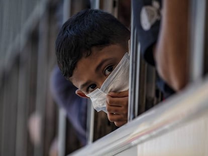 Un niño con mascarilla se asoma a la ventana de un autobús en Manila, capital filipina, el 13 de marzo de 2020. La ciudad está en cuarentena para prevenir el avance del coronavirus. 