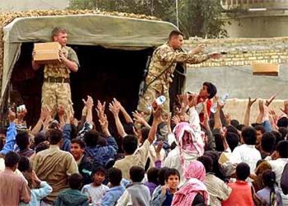 Soldados británicos reparten comida ayer en la localidad de Az Zubayr, cerca de Basora.