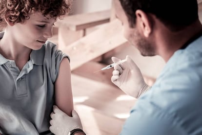 Um médico vacina a uma criança.
