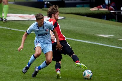 Iker Muniain, mediapunta del Athletic, protege el balón ante Marcos Llorente este domingo en San Mamés.