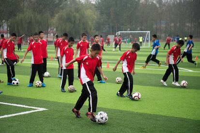 En la última fase, la meta será convertirse en una potencia mundial, según la Comisión Nacional, equivalente a un ministerio de Fomento. En la imagen, varios niños durante un entrenamiento en un campo de césped artificial.