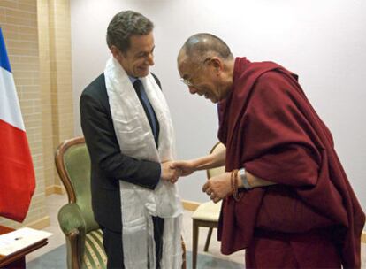 El presidente francés, Nicolas Sarkozy, estrecha la mano al Dalai Lama.