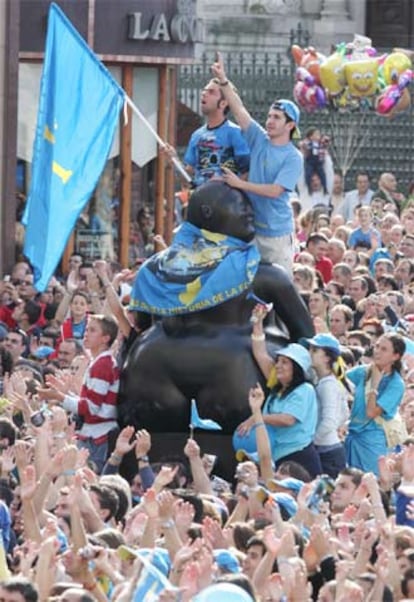 Aficionados subidos a una de las gordas de Botero.