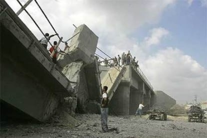 Habitantes de Gaza examinan un puente destruido por la aviación israelí cerca de la ciudad de Gaza.