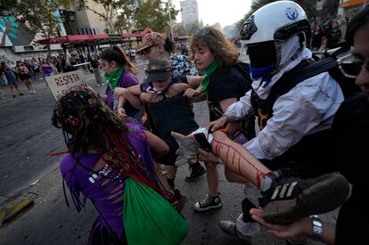Manifestantes cargan a una mujer herida durante las protestas en Santiago.