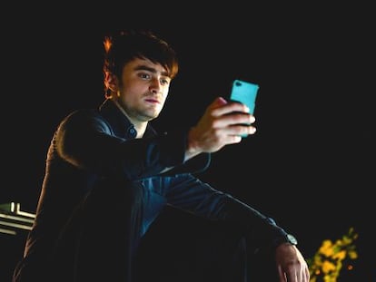 Daniel Radcliffe mirando en soledad la pantalla de su 'smartphone' en la película 'Amigos de más' (2013).