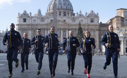 Integrantes da equipe de atletismo do Vaticano correm para a imprensa em frente à basílica de São Pedro.