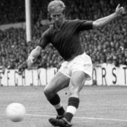 Retrato del jugador de fútbol inglés Bobby Charlton, dando una patada al balón durante un partido de fútbol.