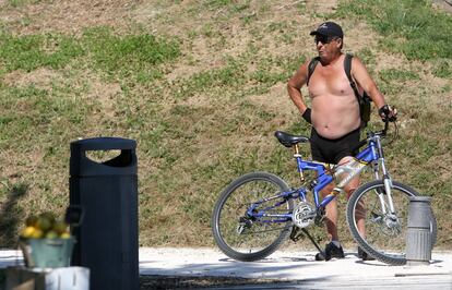 Un hombre descansa tras montar en bicicleta en el Parque Lineal del Manzanares, en Madrid.