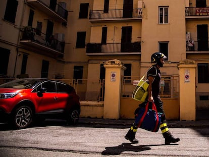 Un bombero porta equipaje durante la evacuación.