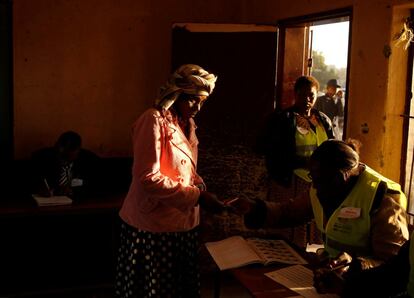 Una mujer espera frente a la mesa electoral para emitir su voto, en Kwekw.
