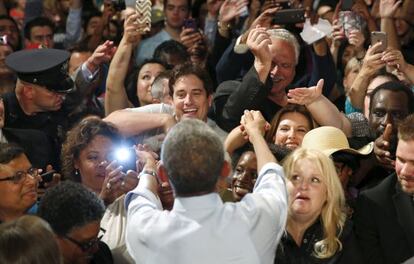 Obama saluda a la audiencia universitaria.