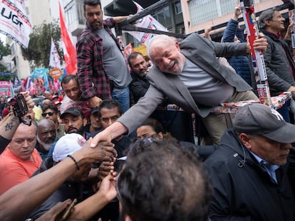 Lula da Silva, candidato a la presidencia, le da la mano a un seguidor en un evento de campaña este sábado, el último día antes de las elecciones, en São Paulo.