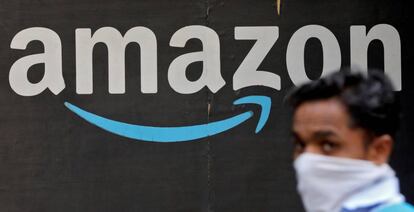 Una persona pasa junto a un logo de Amazon.
