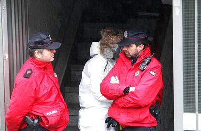 Agentes de la Ertzaintza custodian la entrada al edificio donde fue perpetrado el doble asesinato de los ancianos de Otxarkoaga (Bilbao).
