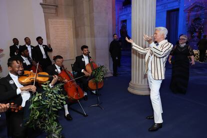 Baz Luhrmann, actor y director, celebra el acompañamiento musical de la gala con la diseñadora Catherine Martin acercándose por detrás.