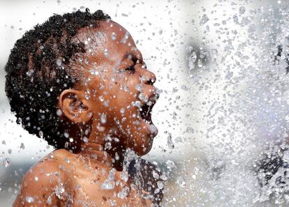 Un niño juega en una fuente durante un caluroso día de verano en Bruselas (Bélgica).