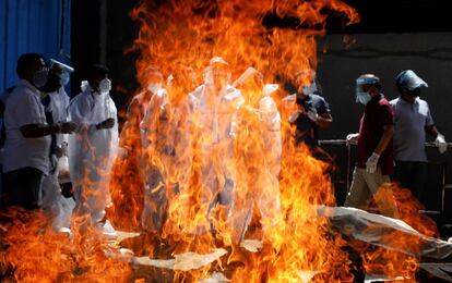 Familiares con equipos de protección personal asisten al funeral de un fallecido por coronavirus en un crematorio en Nueva Delhi (India). La covid-19 ha dejado hasta el momento cerca de 143 millones de casos en el mundo tras sumar más de 550.000 durante el último día, según los datos publicados este martes por la Universidad Johns Hopkins a través de su página web.