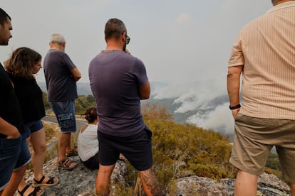 Vecinos observan las columnas de humo que se elevan sobre el incendio forestal en Chandrexa de Queixa (Ourense), el miércoles.