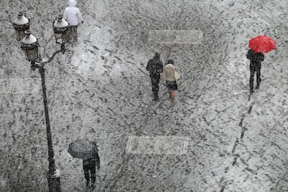 Un grupo de personas caminan sobre placas de hielo, cerca de la plaza de la Bolsa de París.