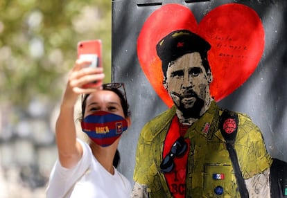 Una dona es fa una foto amb el grafiti de Messi vestit de Che Guevara.