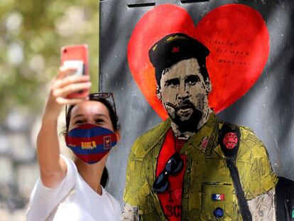 Una dona es fa una foto amb el grafiti de Messi vestit de Che Guevara.