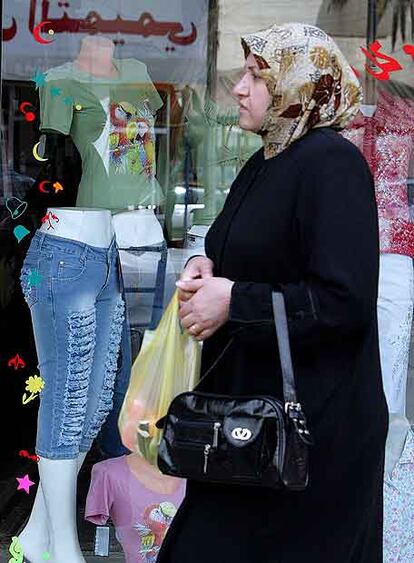 Una mujer camina ante un escaparate de una tienda de moda en Bagdad, el pasado marzo.