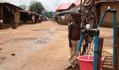 Un niño permanece junto a una bomba de agua instalada por una empresa minera china en Masumbiri, Sierra Leona, el 26 de julio de 2019.