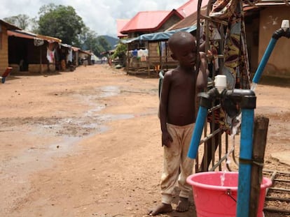 Un niño permanece junto a una bomba de agua instalada por una empresa minera china en Masumbiri, Sierra Leona, el 26 de julio de 2019.