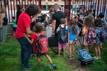 Varios padres se despiden de sus hijos a la entrada del colegio en el primer día de clase en Madrid.