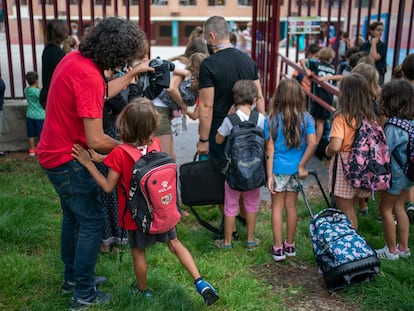 Varios padres se despiden de sus hijos a la entrada del colegio en el primer día de clase en Madrid.
