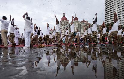 Indios practican yoga frente al hotel Taj, en Mumbai, India, este martes.