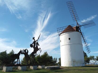 Un molino de viento junto a un perfil metálico de Don Quijote, cerca de Almodóvar del Campo (Ciudad Real).
 