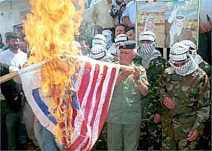 Manifestantes palestinos queman banderas de Israel y EE UU ayer en el campo de refugiados de Ain el Hilweh.