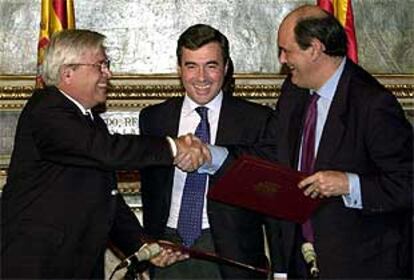 El alcalde de Barcelona y el secretario de Estado de Seguridad estrechan sus manos ante el ministro Acebes.