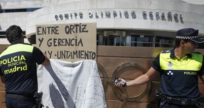 La policía retira una pancarta colocada en la puerta del Comité Olímpico Español